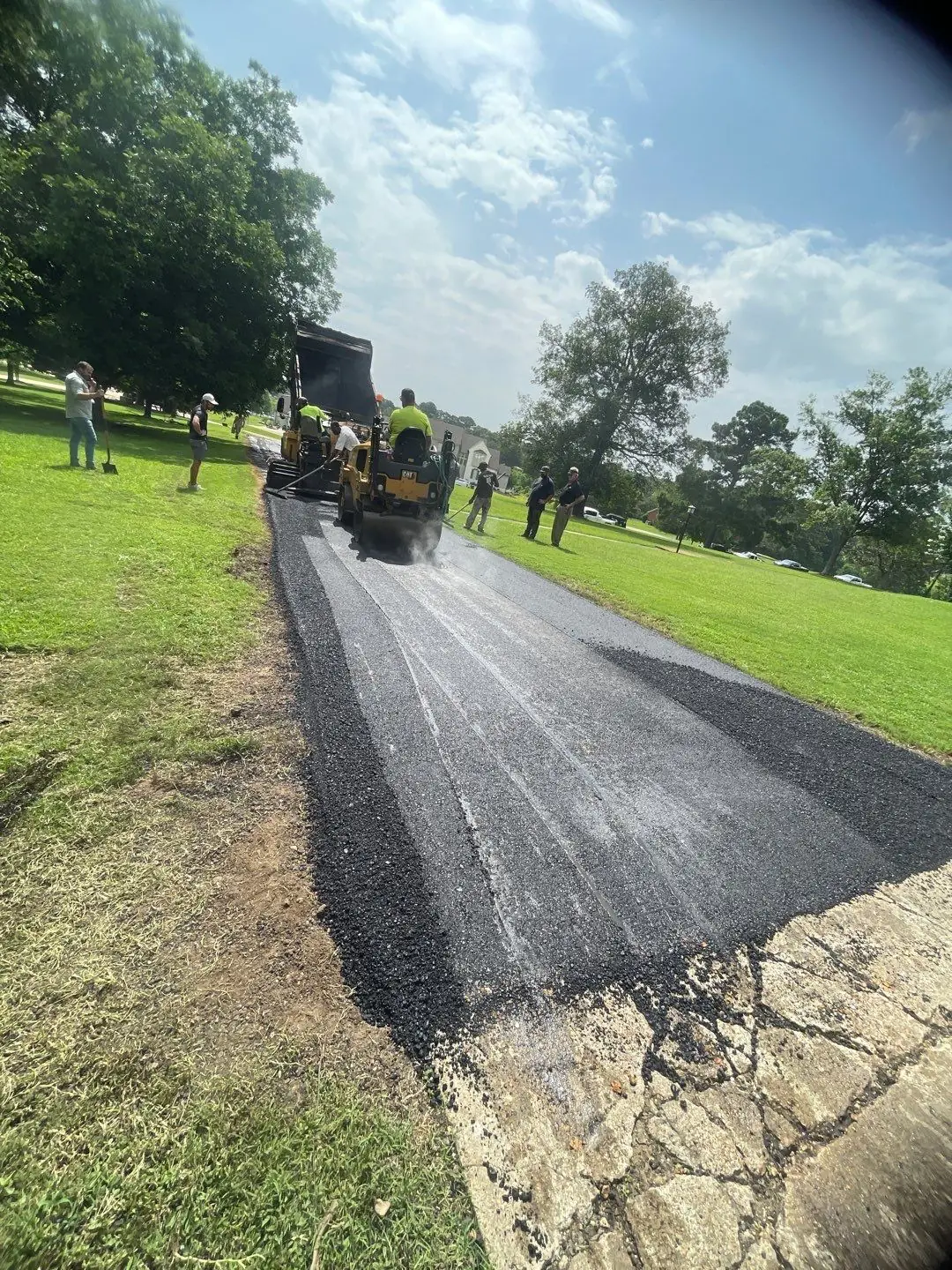 PavePro crew compacting a newly paved asphalt driveway with a roller.